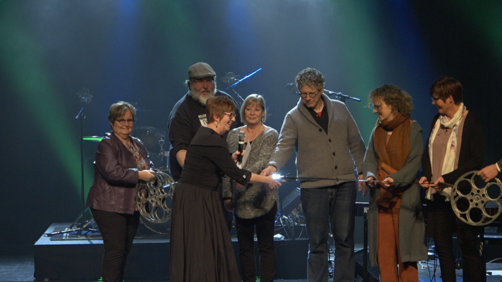 2022 Belleville Downtown Docfest Board Members gathered to cut a film strip, ribbon, to formally commence the 11th annual Festival